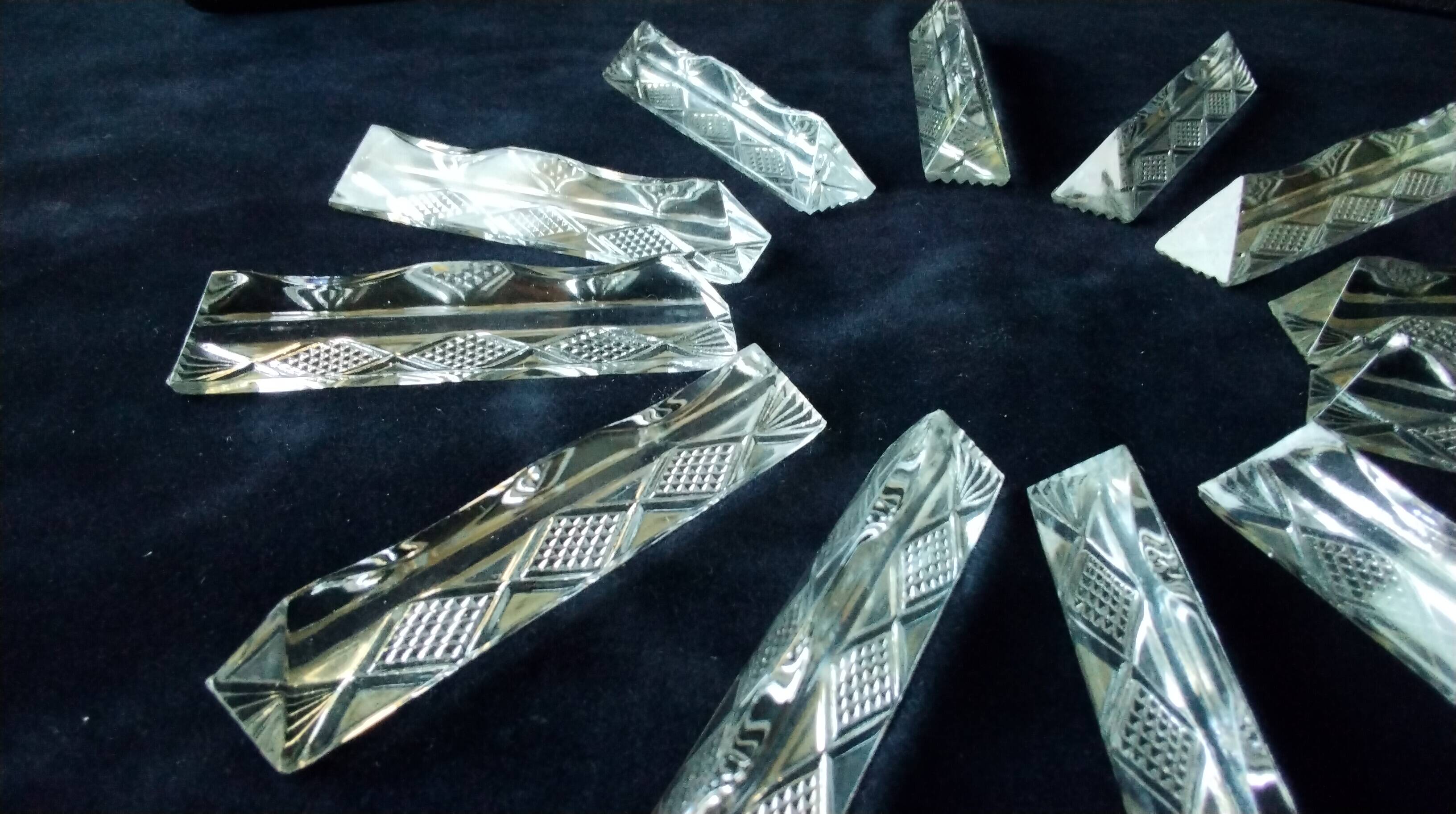 Set of 12 lead crystal knife rests in a triangular shape.