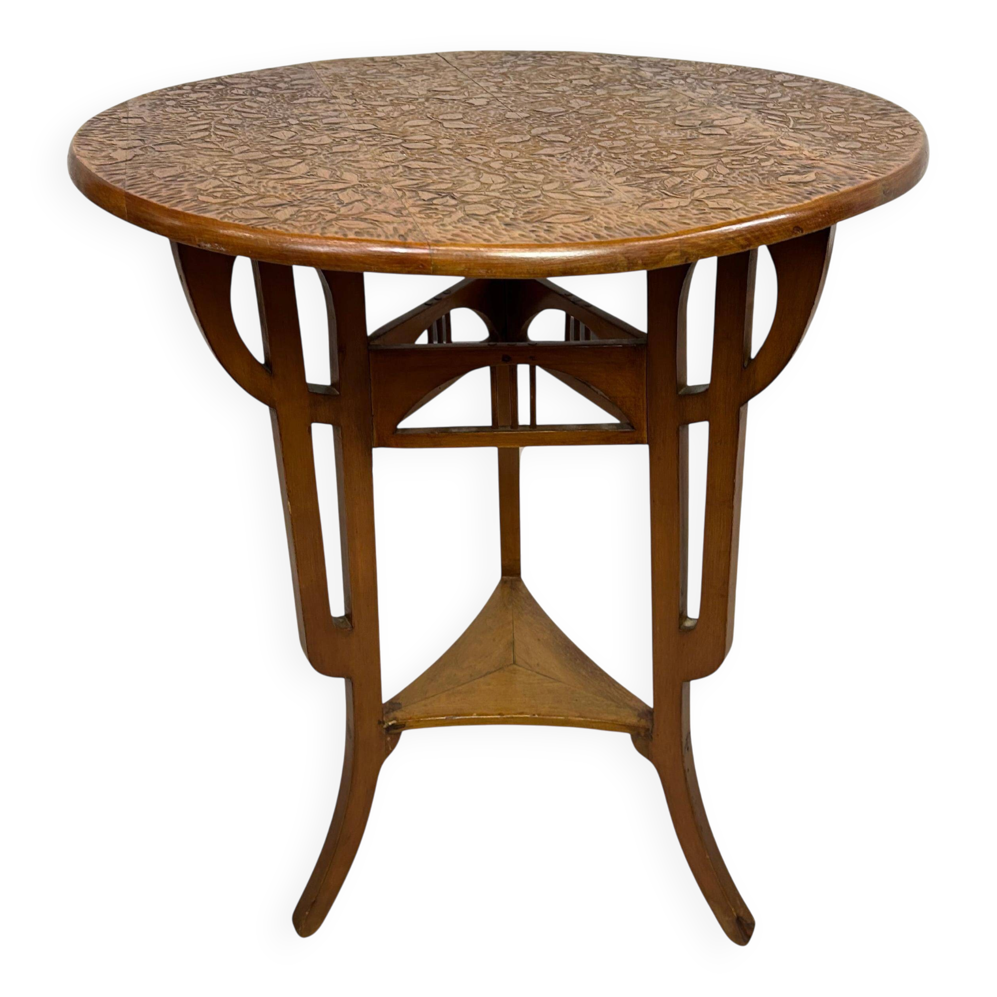 Round Art Nouveau coffee table with a sculpted top.