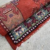 Vintage hand-knotted wool rug with polychrome decoration on a red, blue, green background 150 x 63 cm