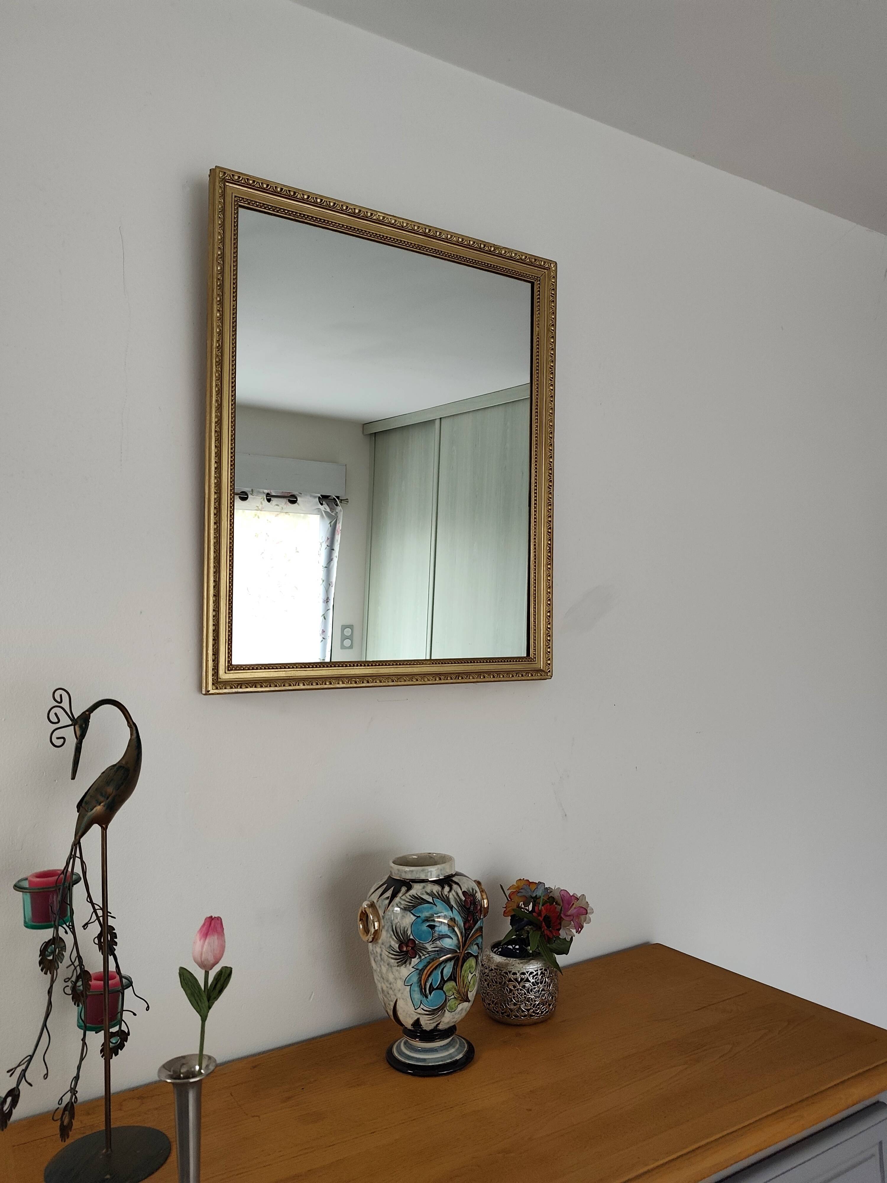Antique mirror with a gilded frame and beaded border.