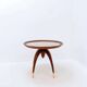 Round Art Deco side table in wood with curved legs and brass feet.