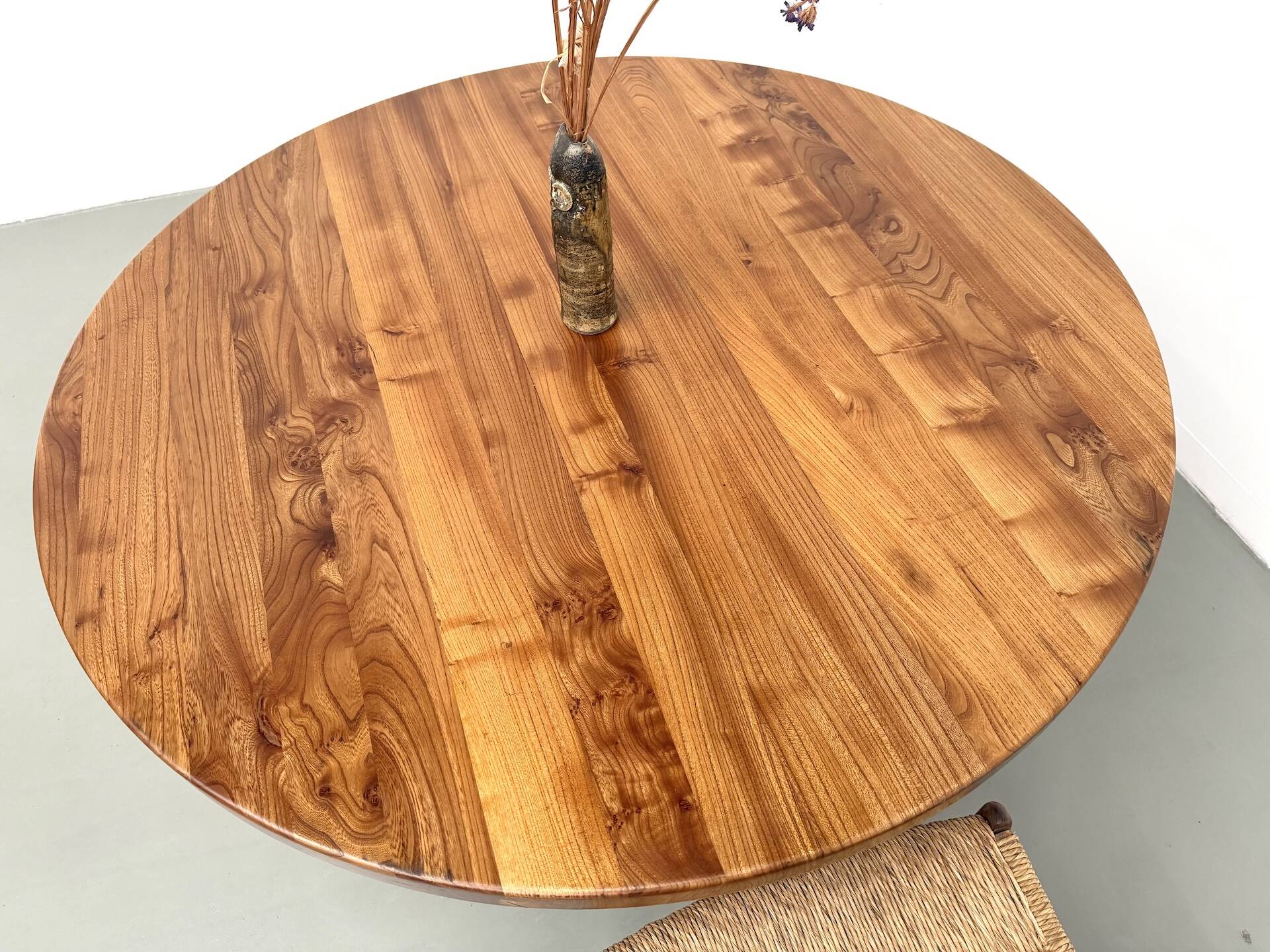 Modernist round table in solid elm, crossed legs.