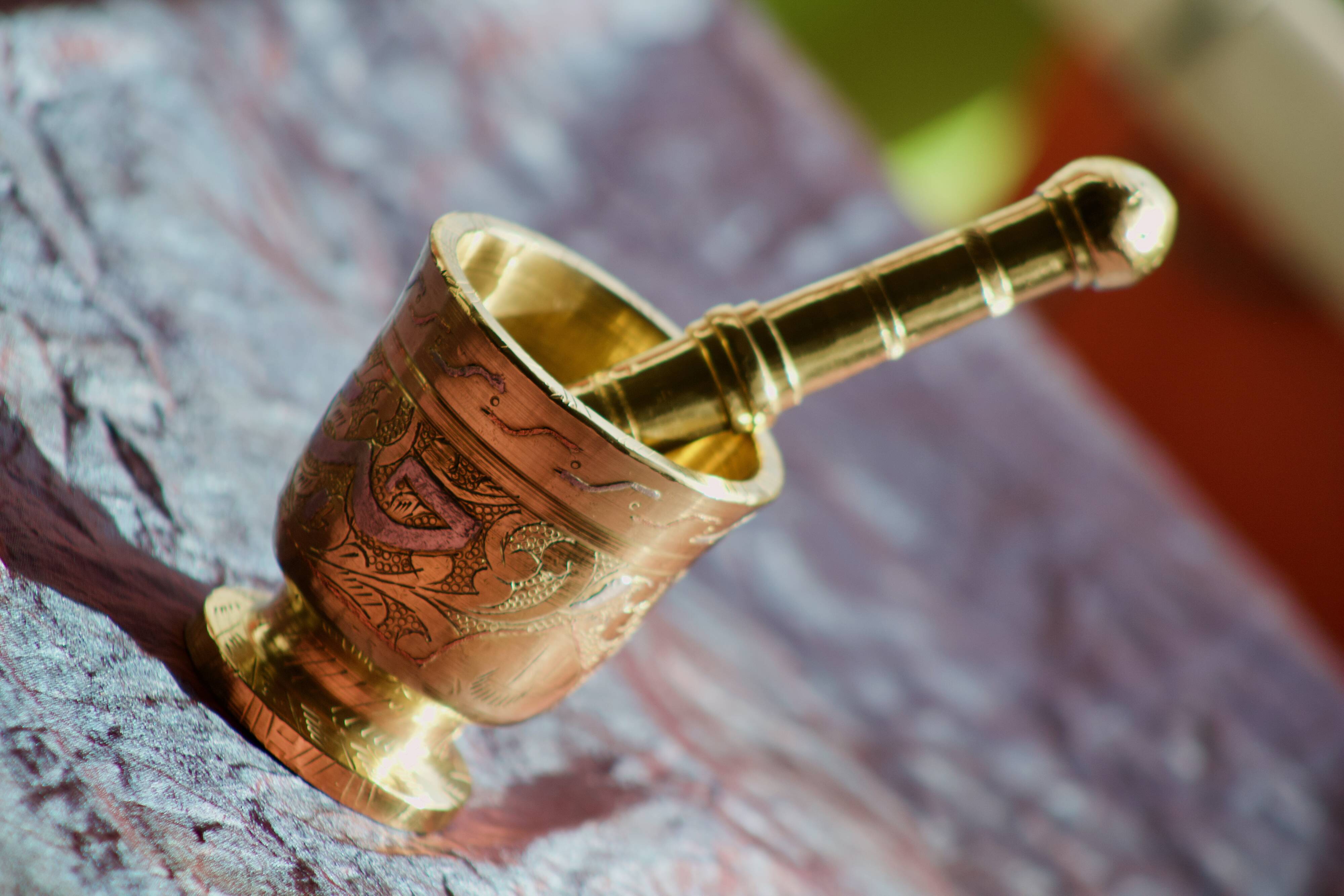 Mortar and its brass pestle with oriental gold and silver motifs