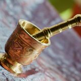 Mortar and its brass pestle with oriental gold and silver motifs