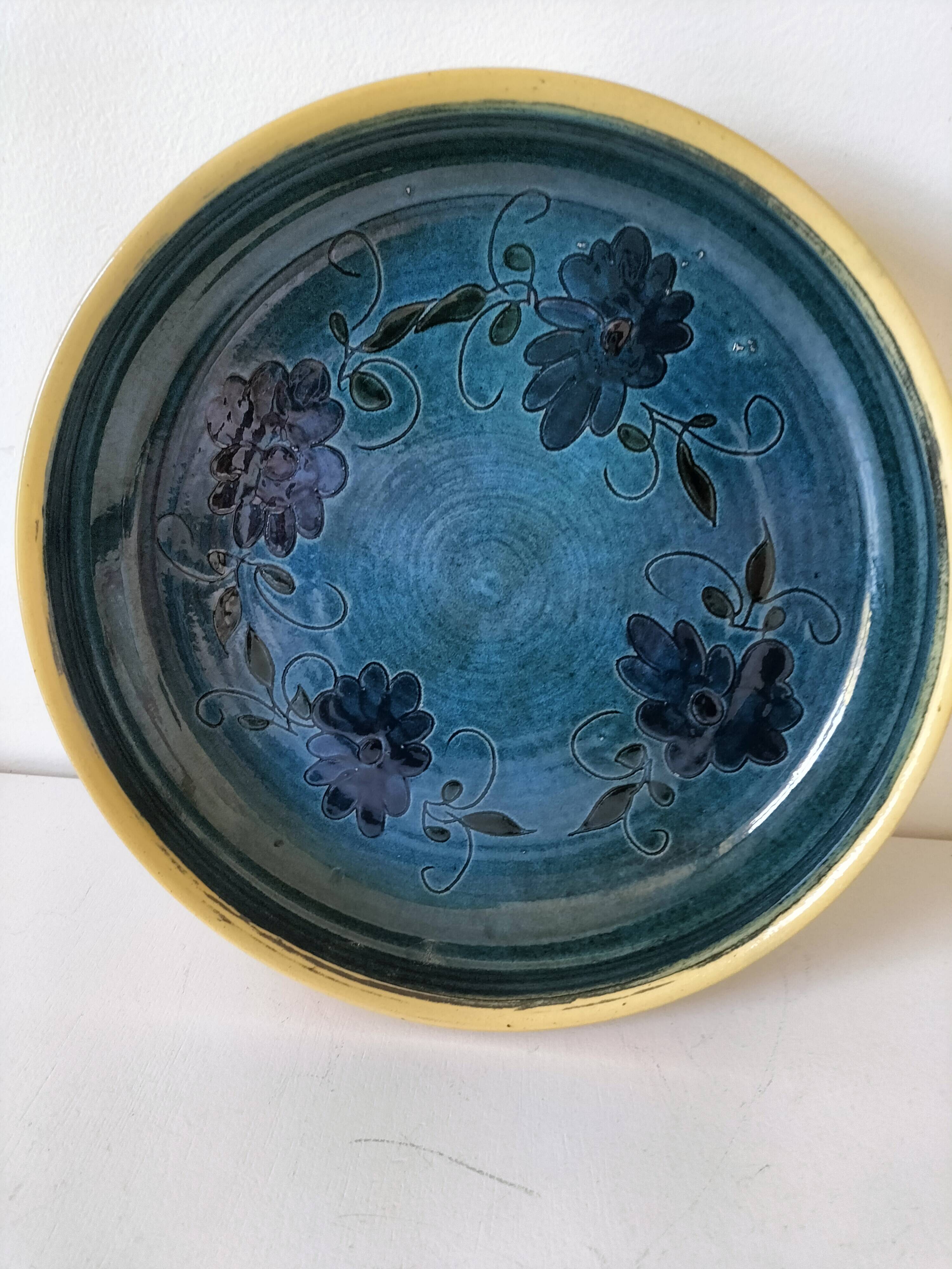 Blue floral glazed stoneware plate with a yellow rim.