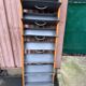 Scandinavian shoe storage cabinet in grey wood and metal.