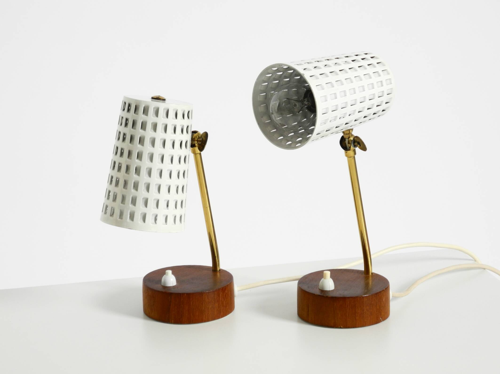 A pair of mid-century modern bedside lamps with perforated metal shades