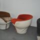 Set of 2 vintage 1970s tub chairs in brown, red, and white fabric with a enveloping silhouette.