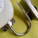 Pair of chrome metal wall lights with white glass globe.