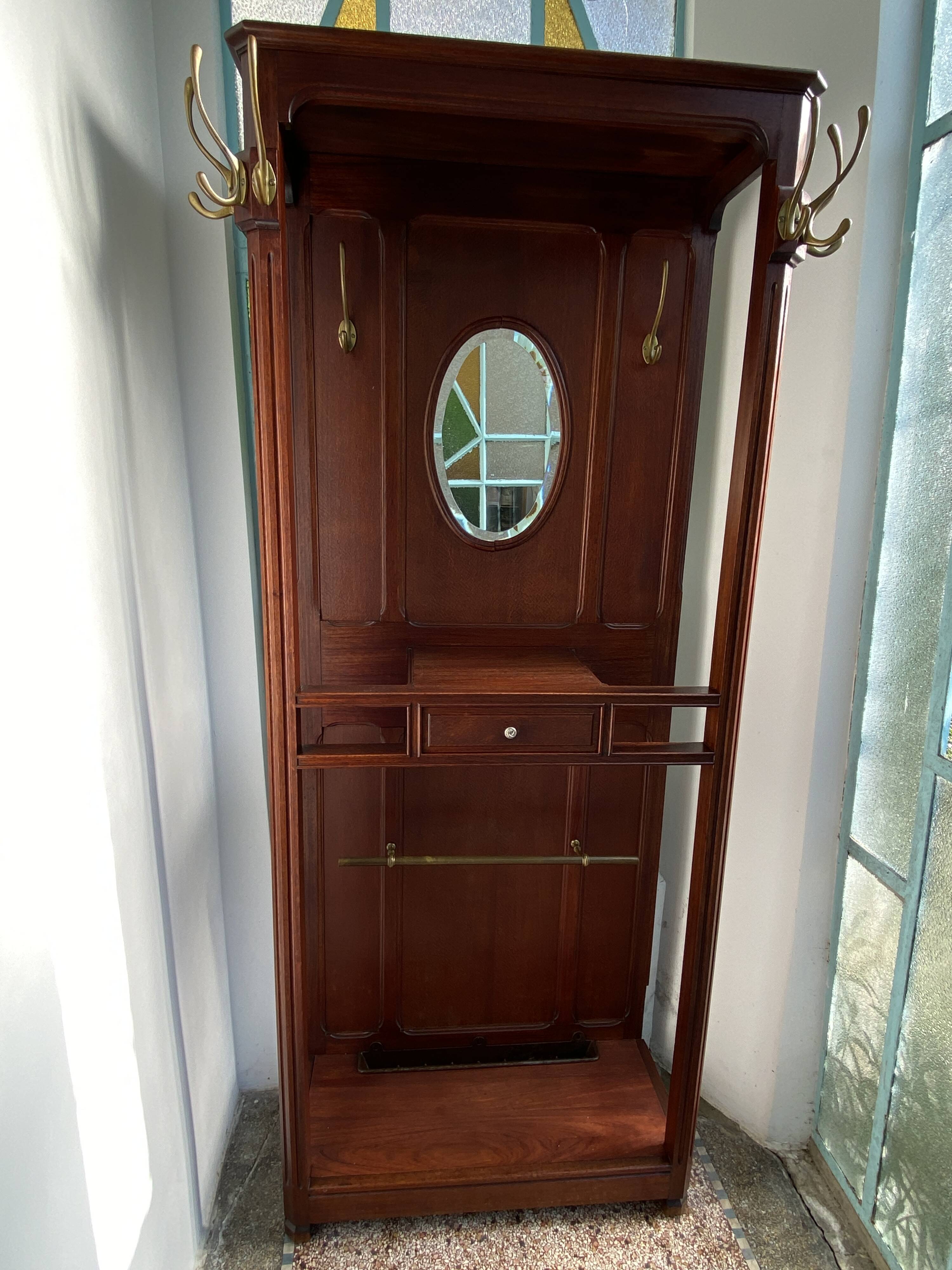 Antique wooden coat rack with mirror and shelf.