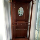Antique wooden coat rack with mirror and shelf.