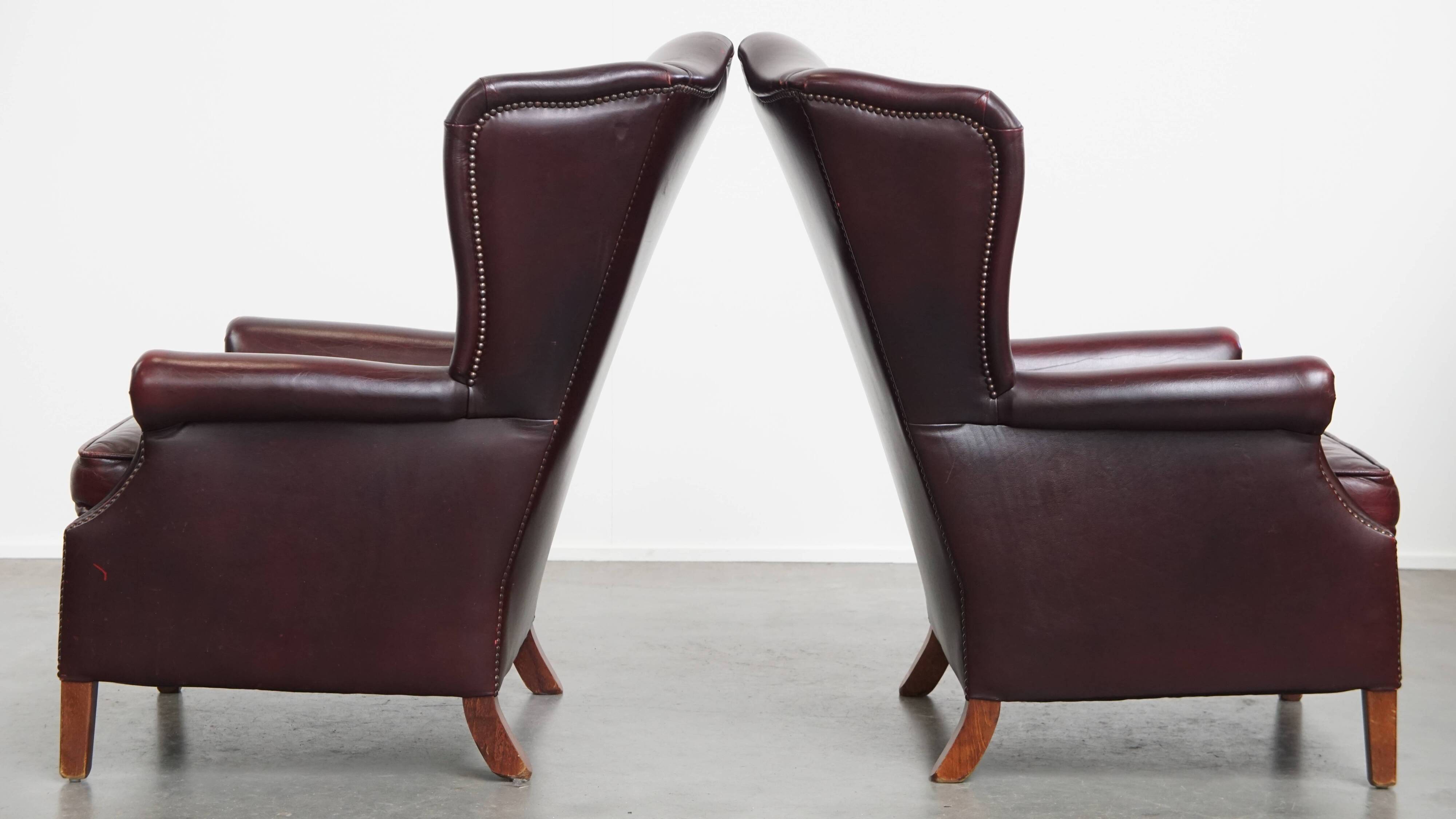 Ensemble de 2 fauteuils à oreilles en cuir de vachette + pouf de style anglais