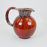 Large red and blue glazed ceramic pitcher signed Delène under the base