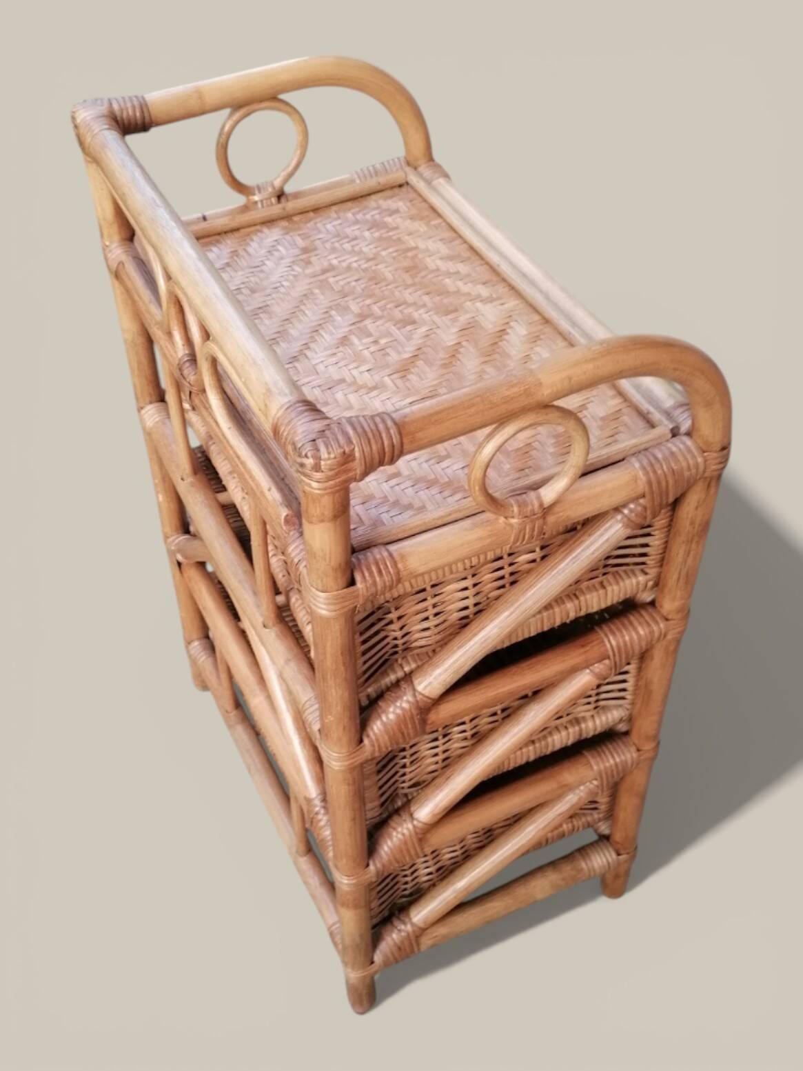 Small storage unit / freestanding shelf in light rattan.