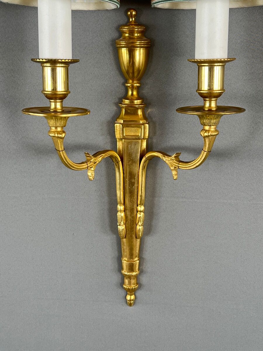 Set of three Louis XVI style wall sconces in gilded bronze, 20th century.