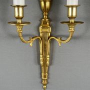 Set of three Louis XVI style wall sconces in gilded bronze, 20th century.