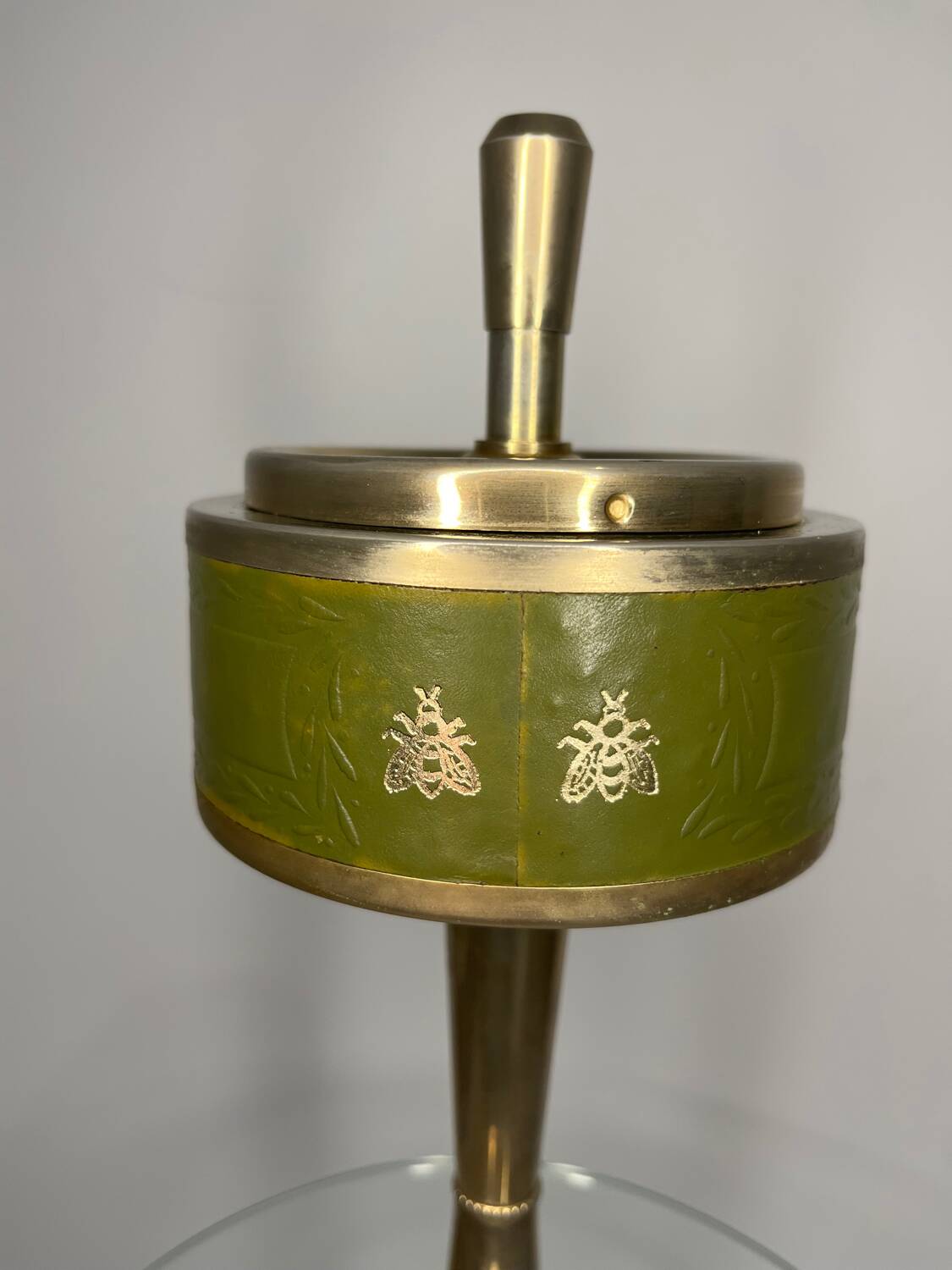 Vintage brass floor ashtray with glass shelf in Empire style.