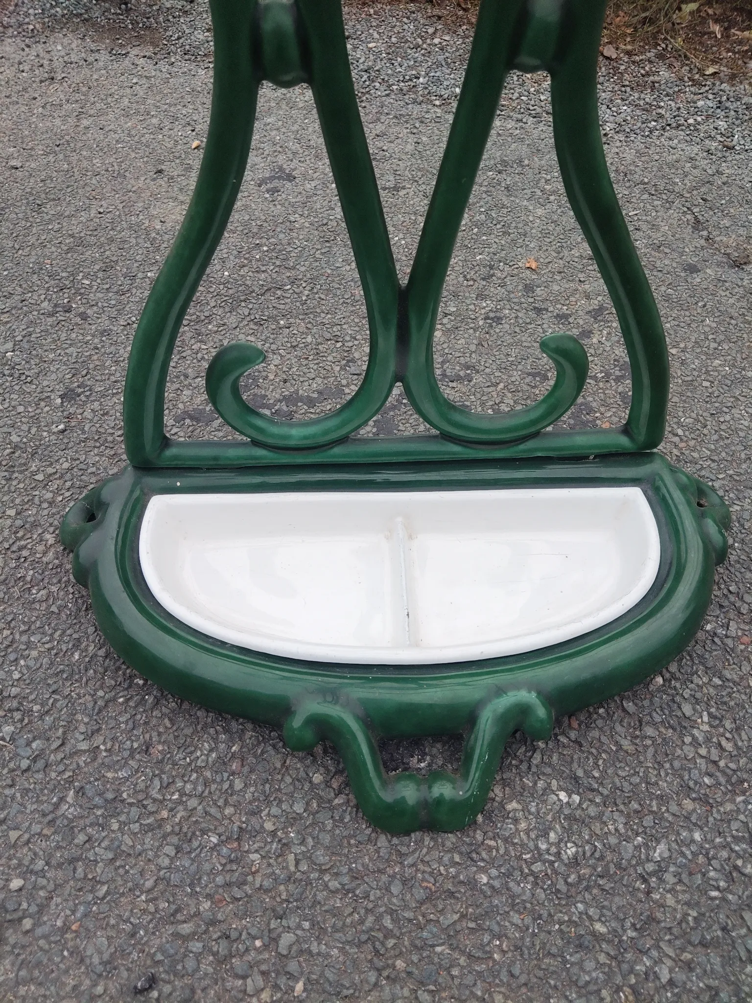 Bottle green enamelled cast iron umbrella stand with a swirl design.