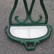 Bottle green enamelled cast iron umbrella stand with a swirl design.
