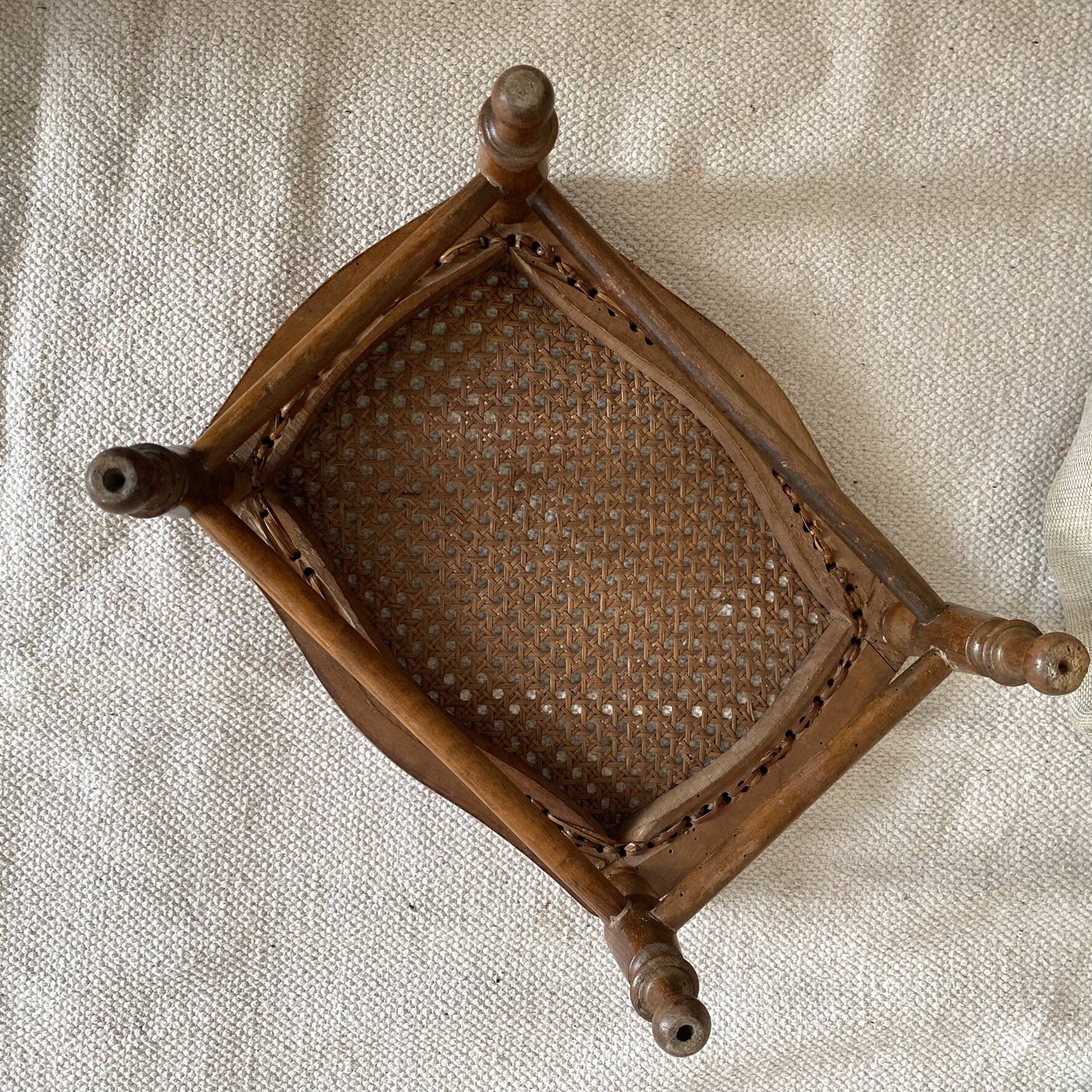 Low wooden stool with caning, footrest.