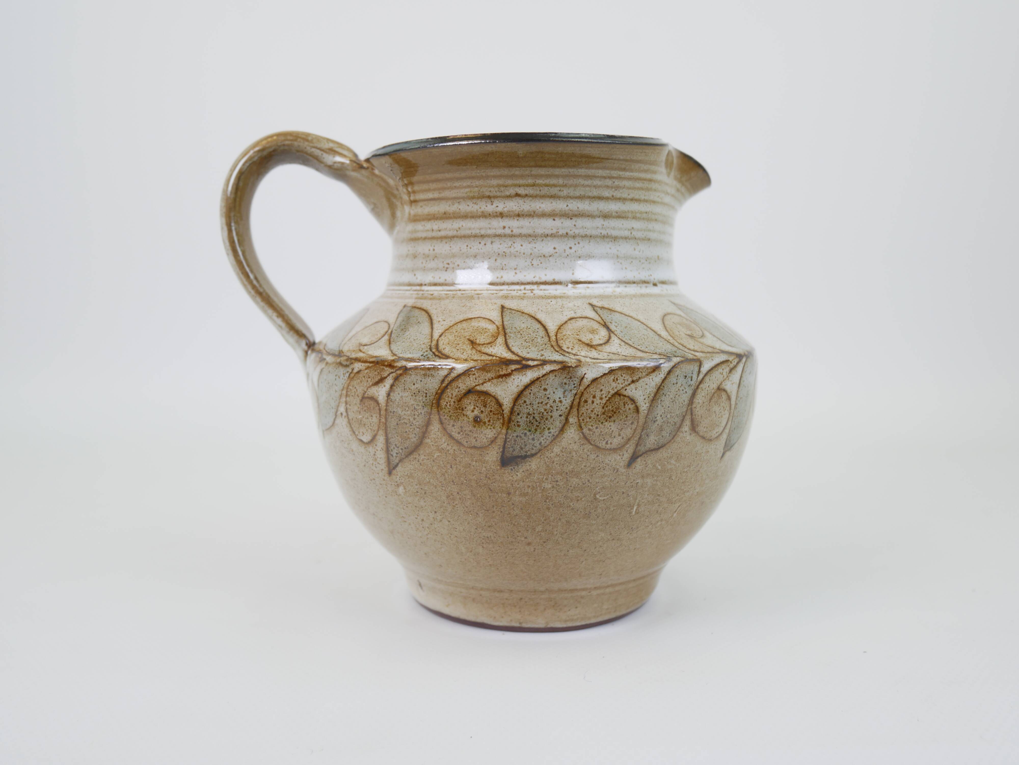 Glazed ceramic jug with plant decoration