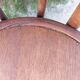 pair of round wooden chairs with a pattern on the seat