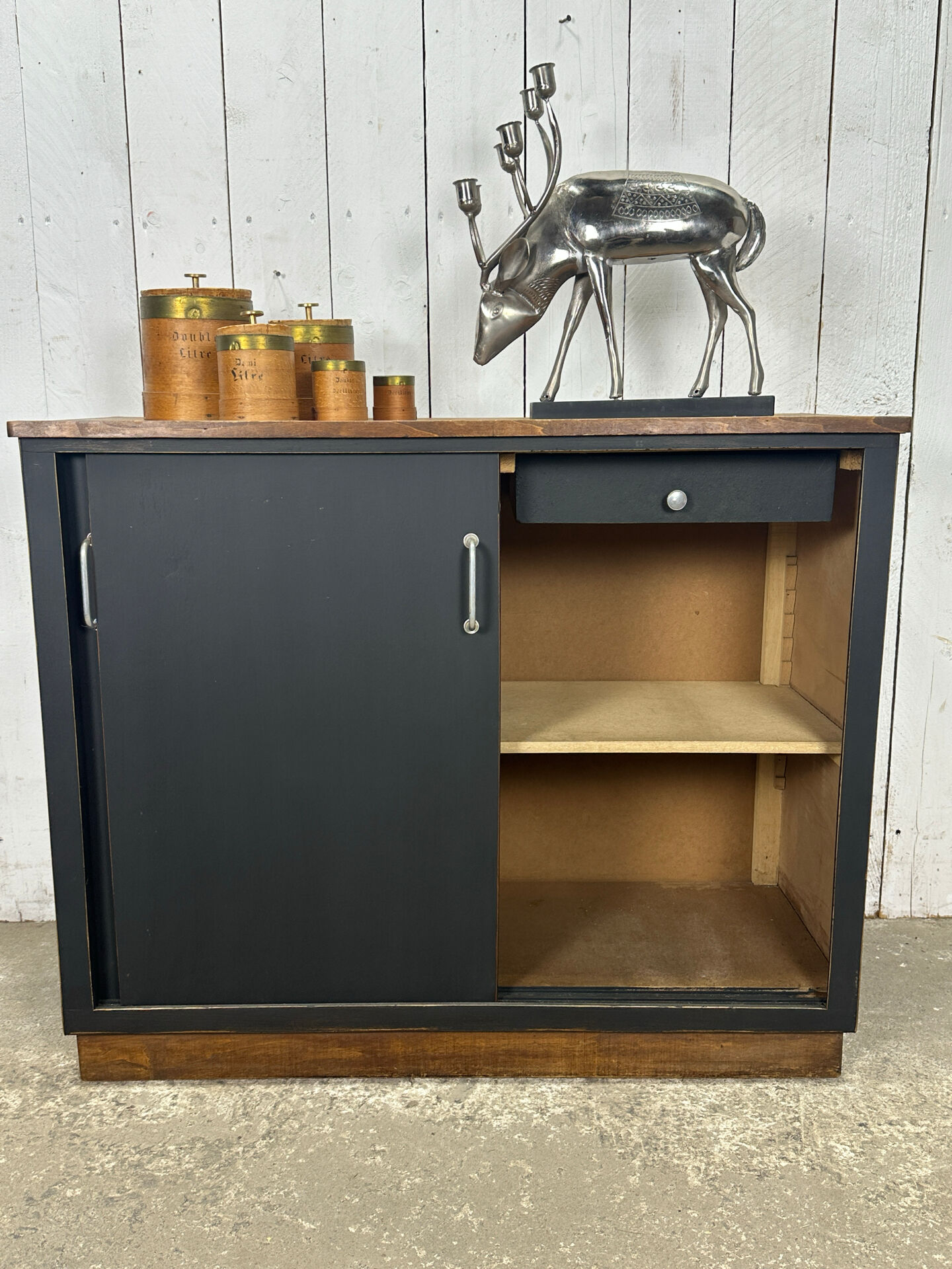 Small vintage black buffet with sliding doors.