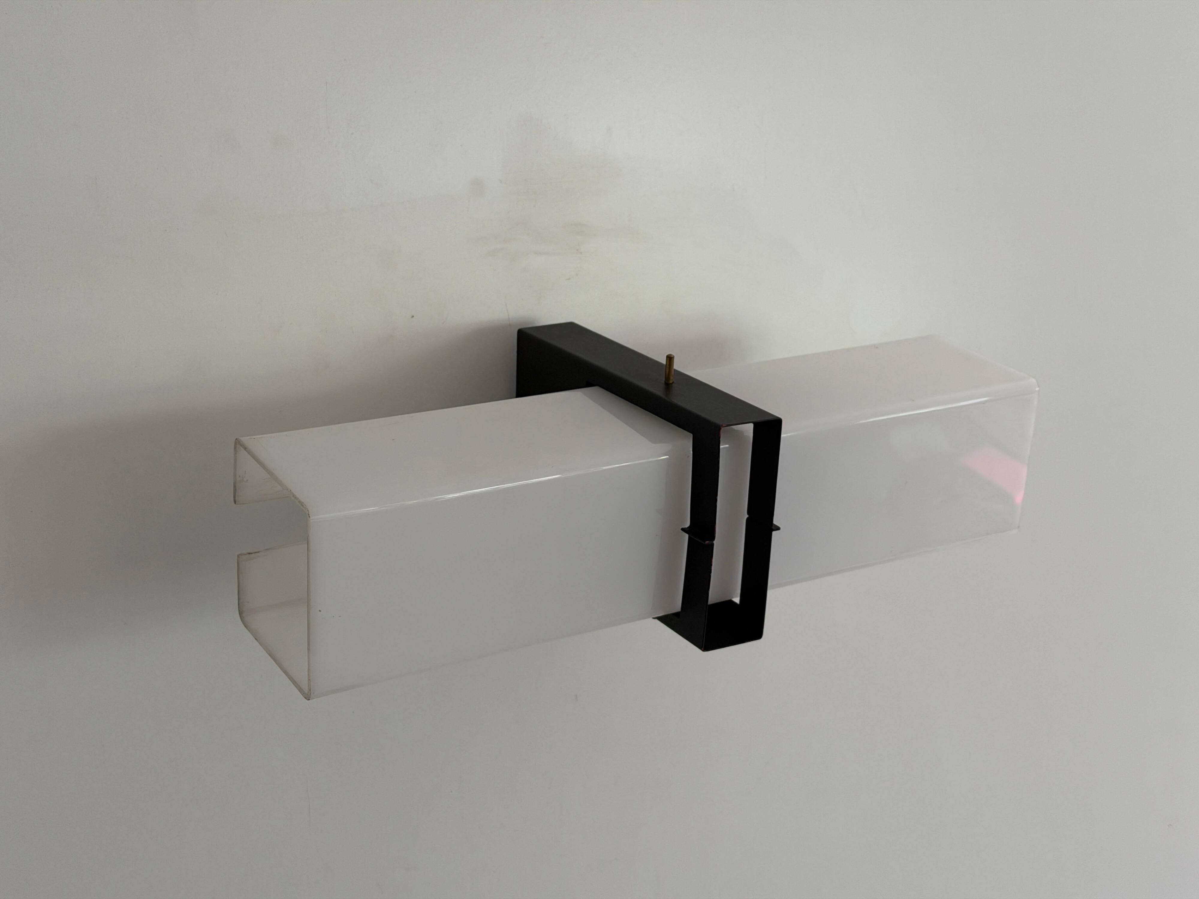 Simple white plexiglass wall light with a black metal frame, 1970s, Germany.