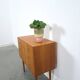 Commode danoise avec de hauts pieds et des poignées dorées.