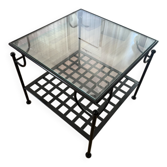 Coffee table with a glass top and black metal frame.