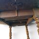 Antique drop-leaf table in wood, with turned legs and castors.
