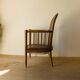 Antique armchair in solid wood and patinated brown leather, early 20th century.