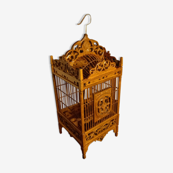 Old bird cage in carved wood and wicker