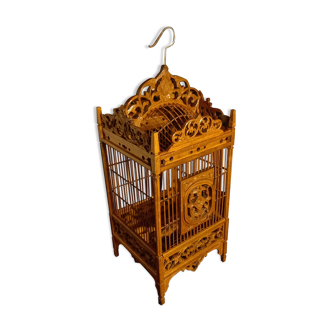 Old bird cage in carved wood and wicker
