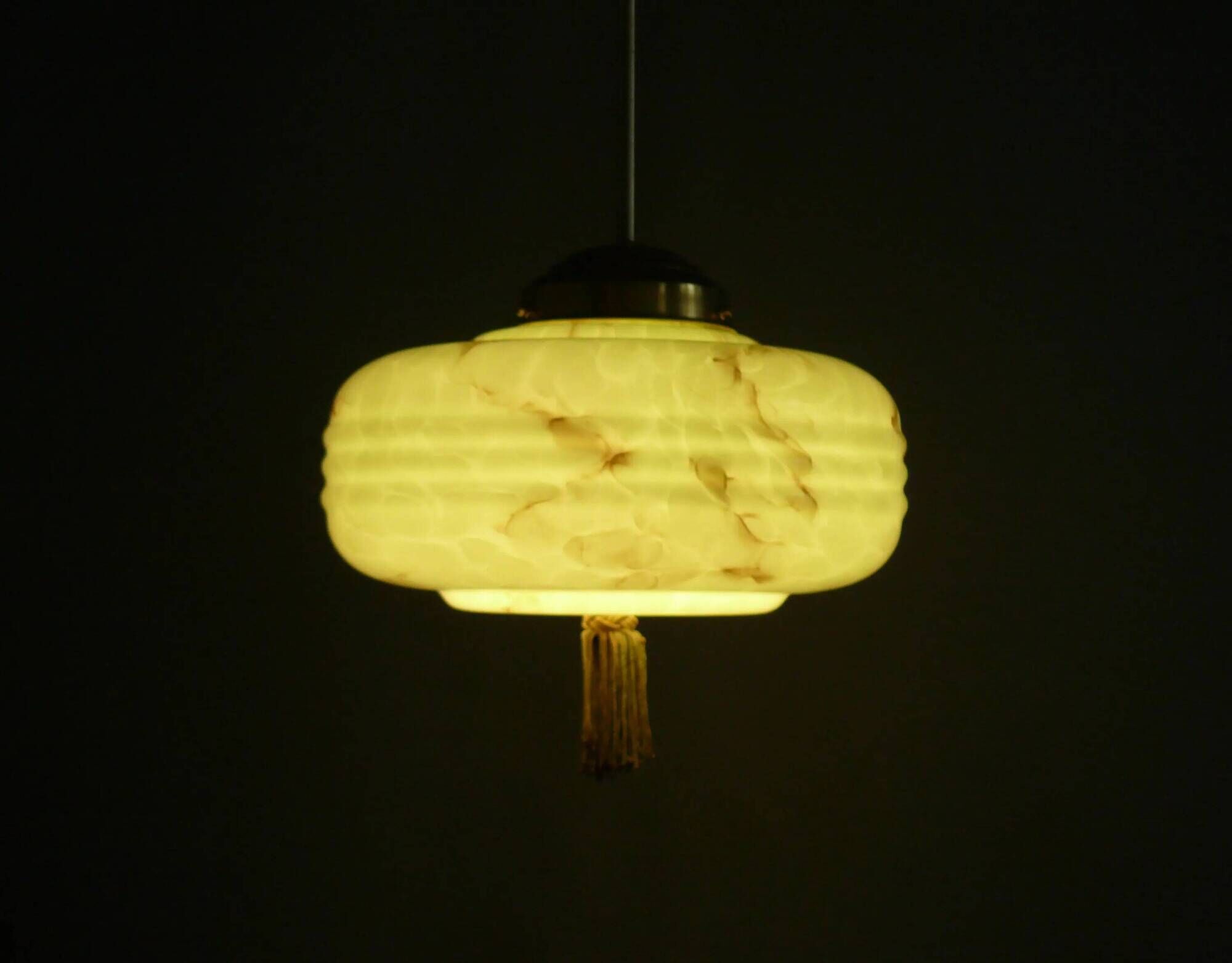 Lampe à pendentif Art Déco avec suspension en laiton et abat-jour en verre marbré.
