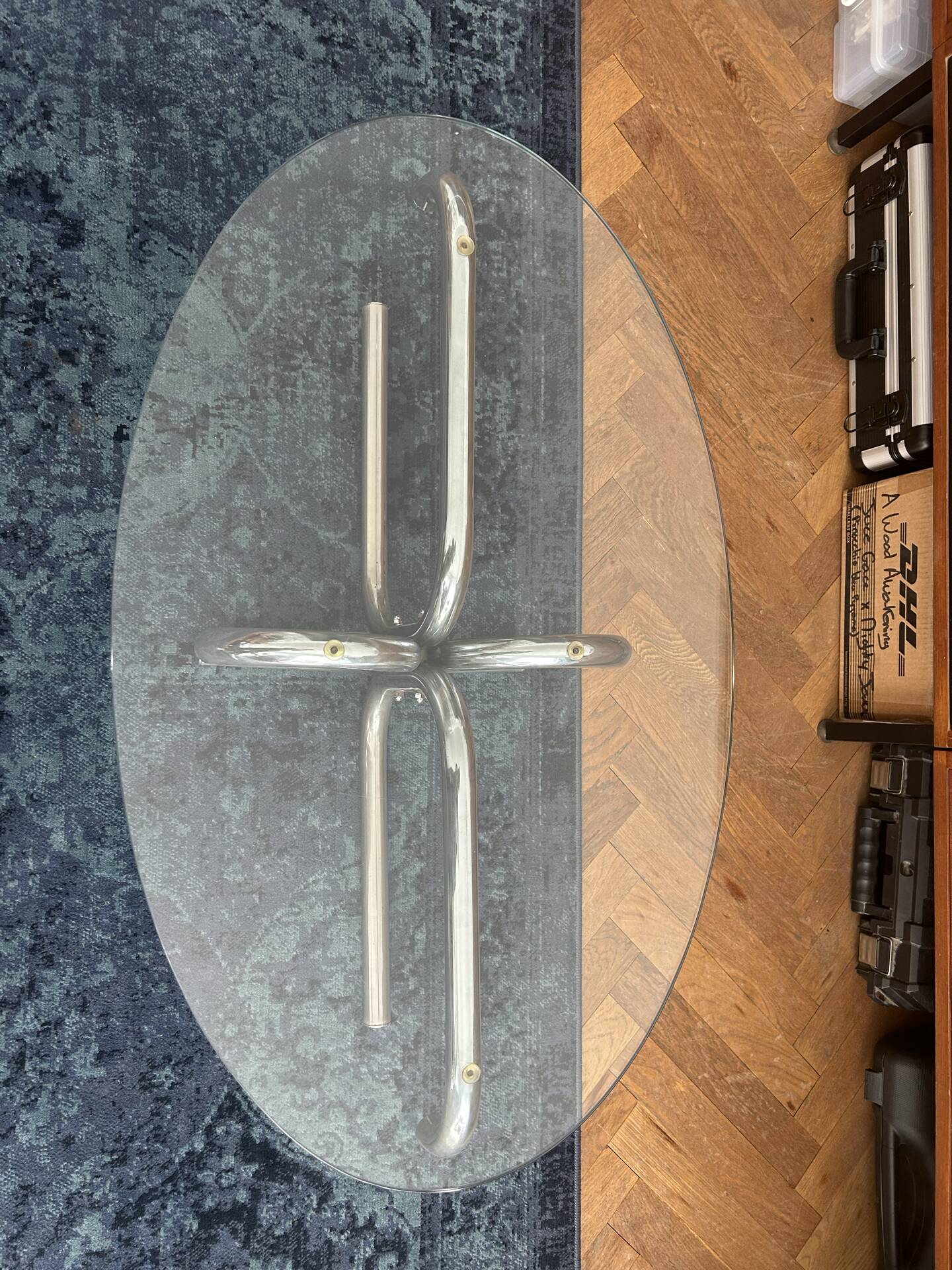 Oval glass coffee table with chrome legs, vintage 70s design.
