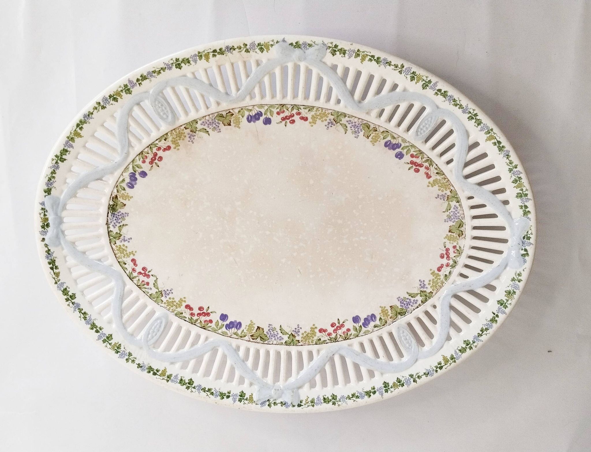 Oval dish in openwork earthenware from Sarreguemines, blue ribbon and fruit