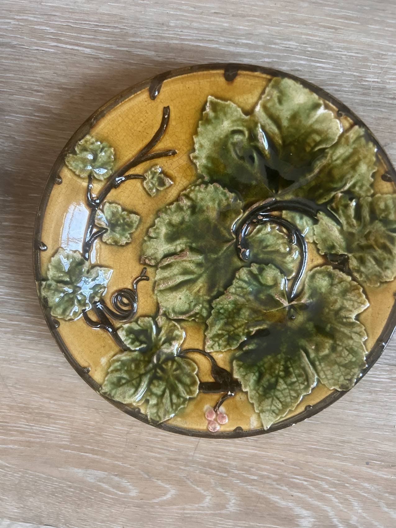 Four antique dessert plates in majolica with vine decoration.