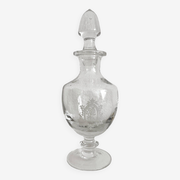 Old bottle on foot in blown glass with medallion engraving