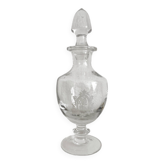 Old bottle on foot in blown glass with medallion engraving