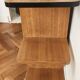 Compact bar cabinet with a pivoting door in black wood.