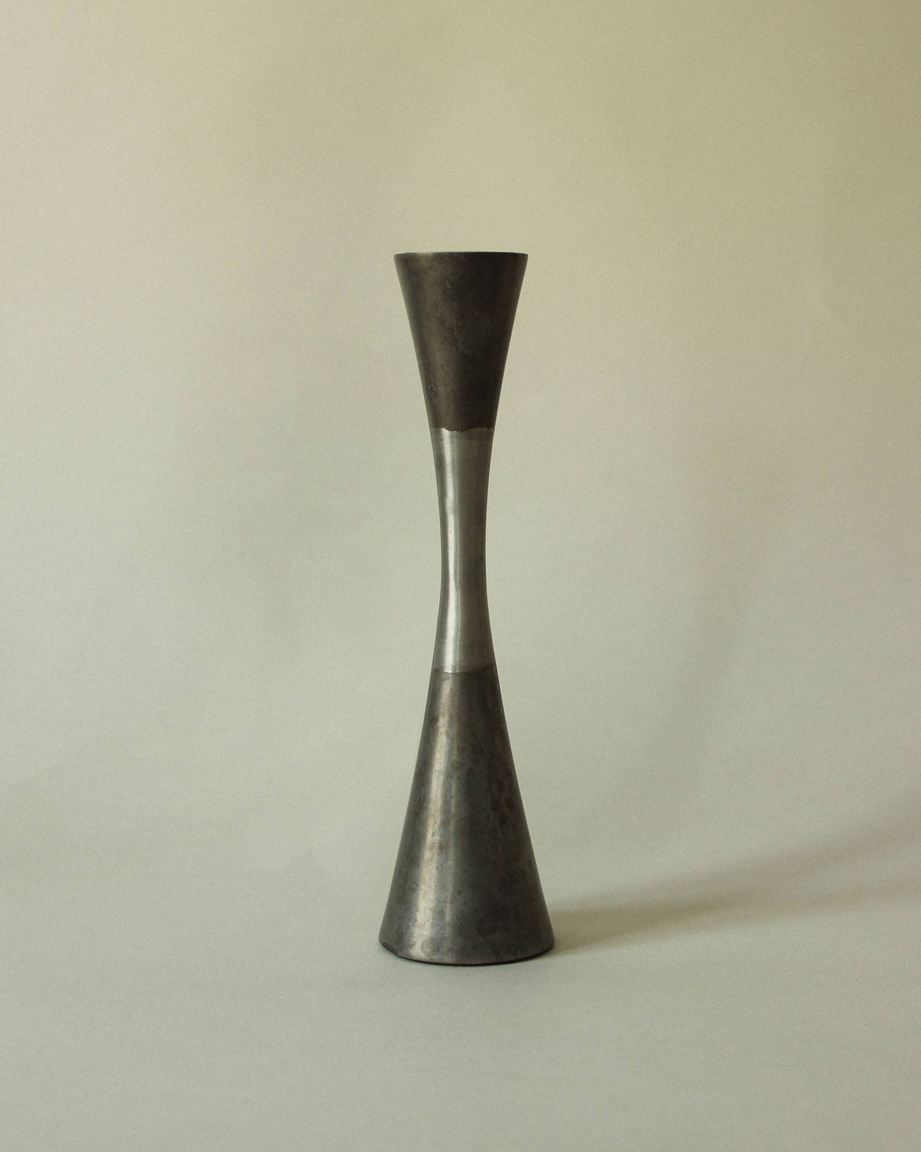 Set of three diabolo-shaped candle holders made of cast steel.