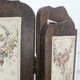 Four-panel oak screen adorned with floral upholstery from the 1930s.
