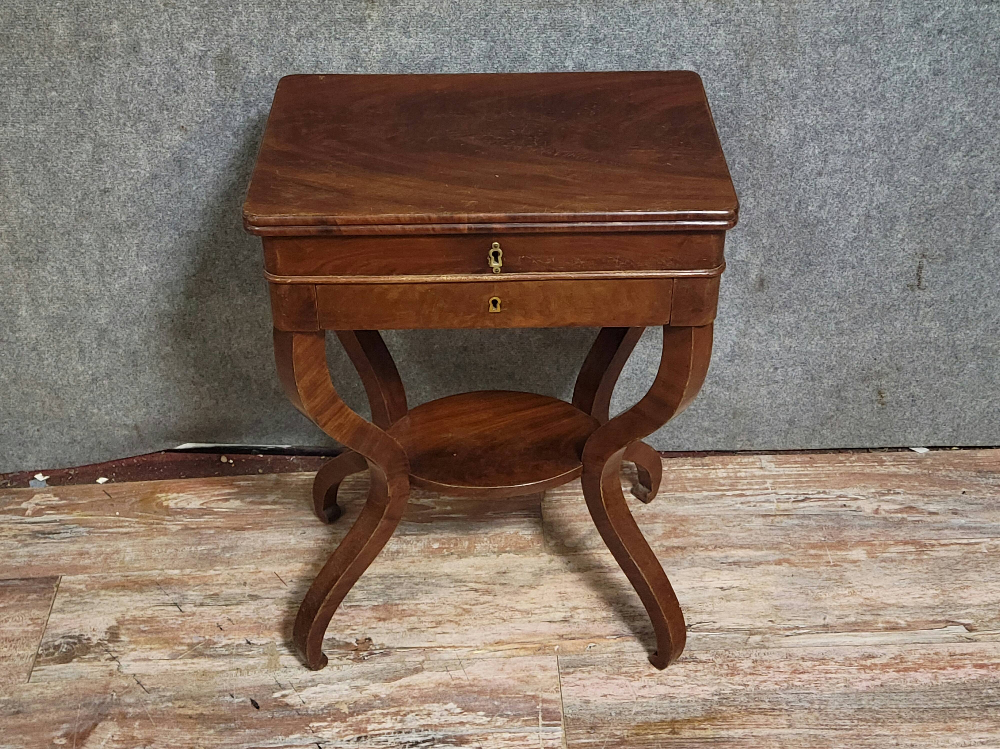 Empire writing table, in mahogany, resting on curved legs.