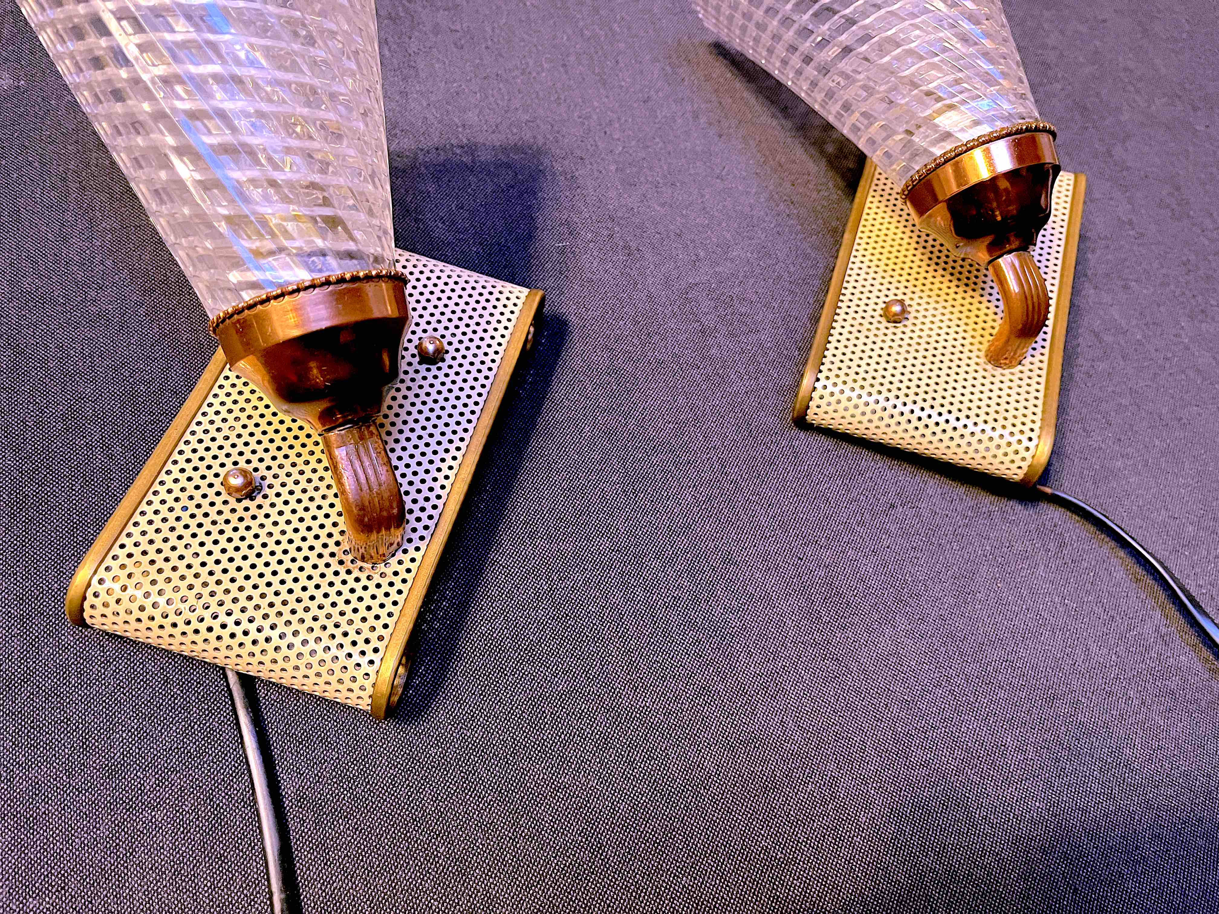 Pair of brass sconces, perforated metal and perhapx conical lampshade, France 50's