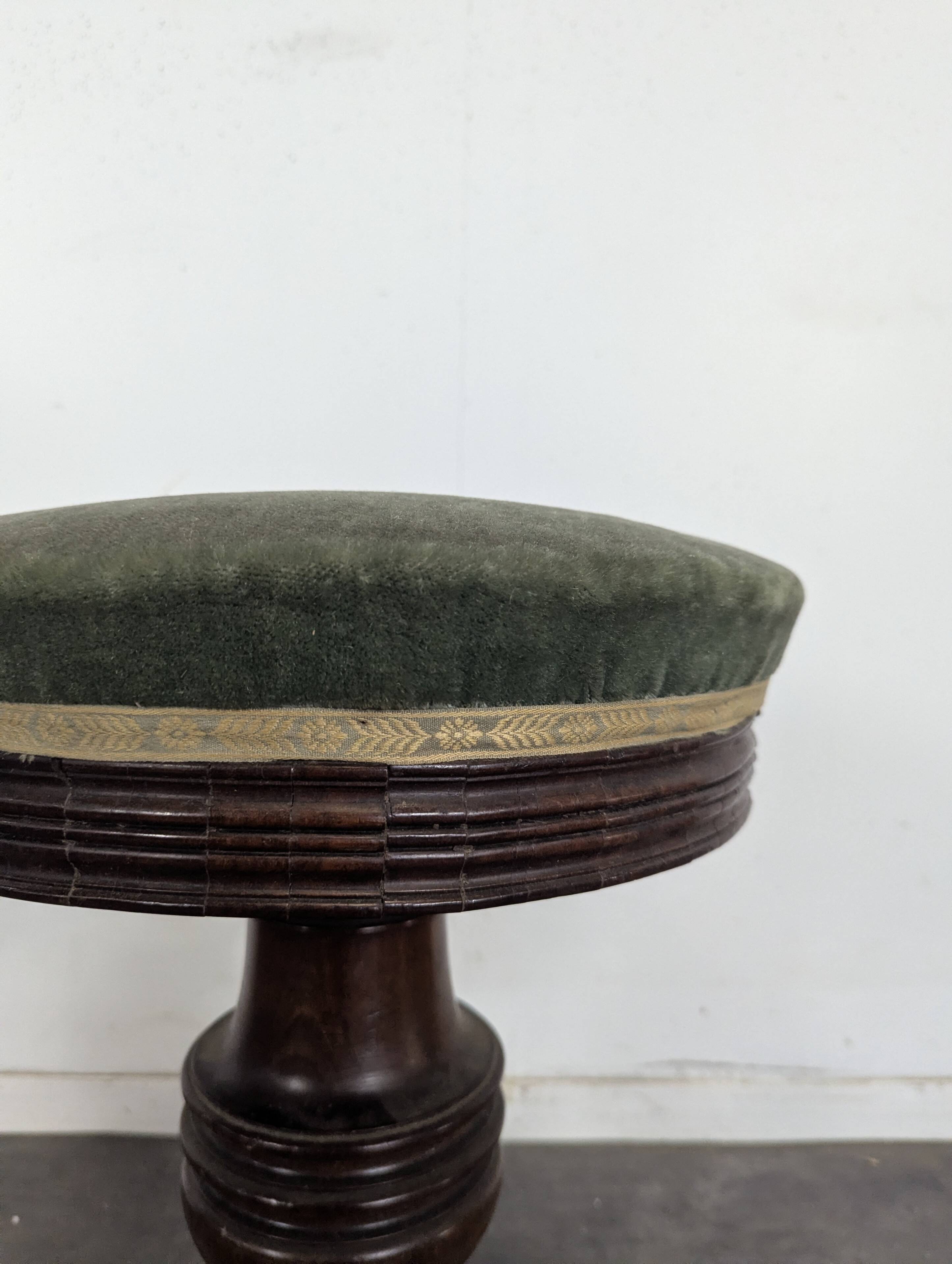 Green velvet piano stool with a turned leg.