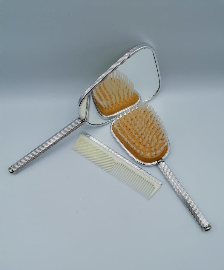 Hand mirror assembly, comb and brush.