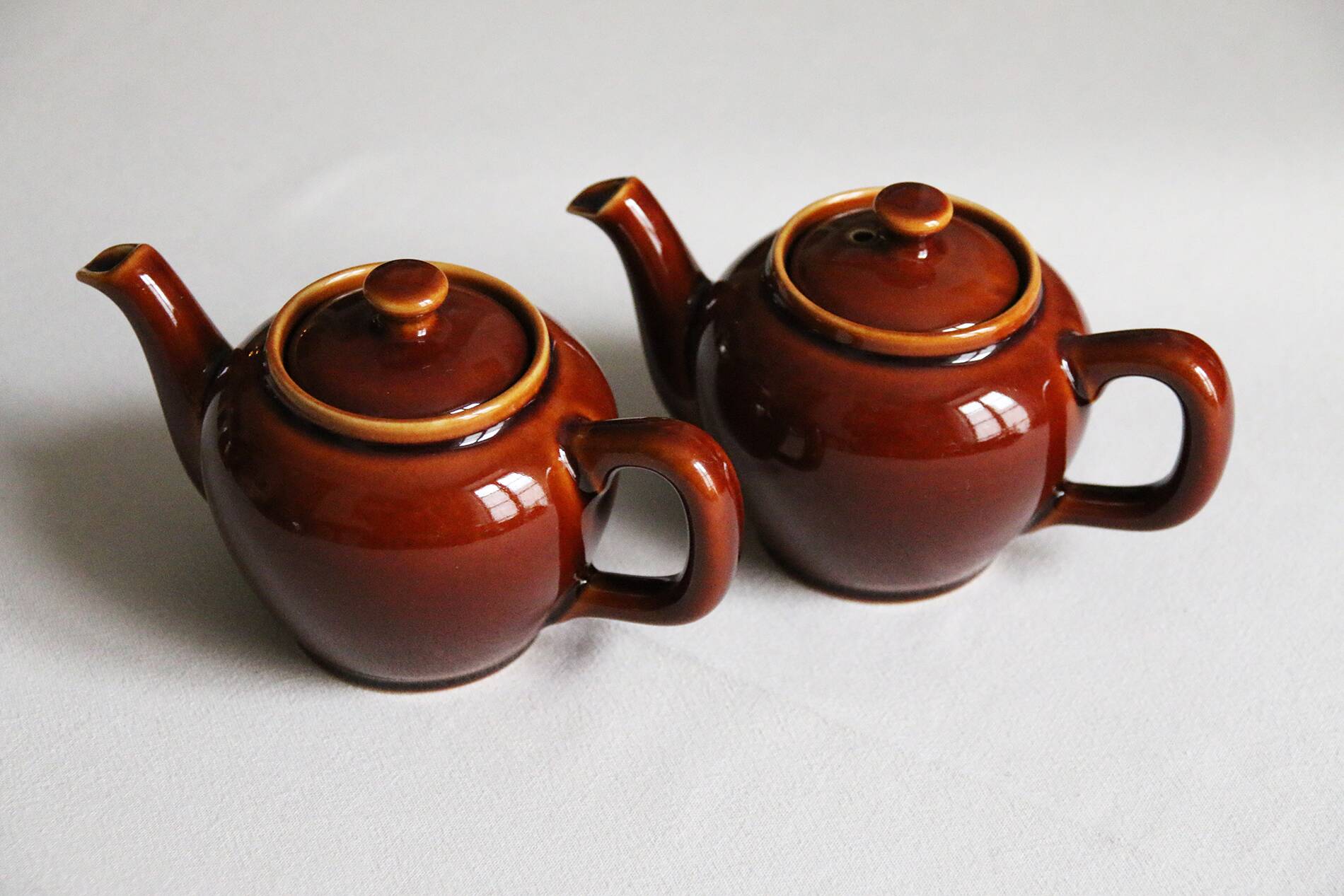2 brown glazed ceramic teapots