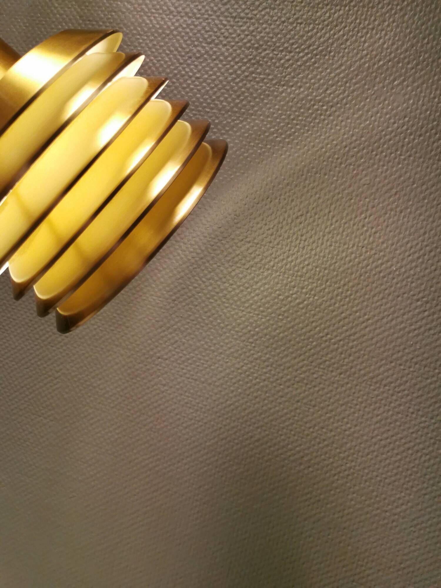 Hanging lamp in gold-colored aluminum with many layers of shades.