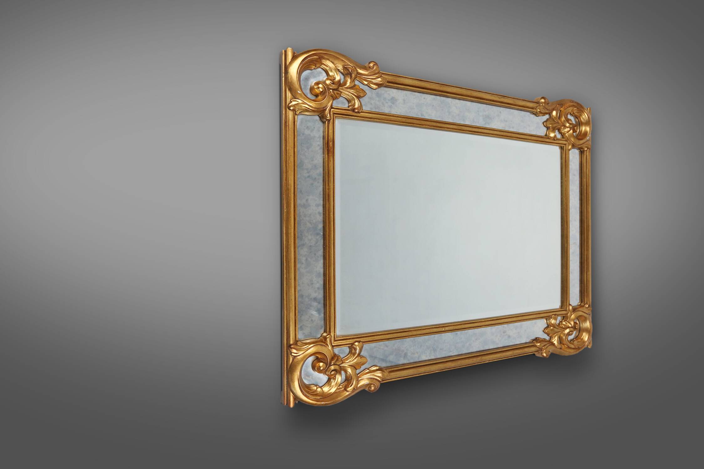 Richly decorated wall mirror in resin with golden ornaments and smoked mirror glass panels, Belgium,